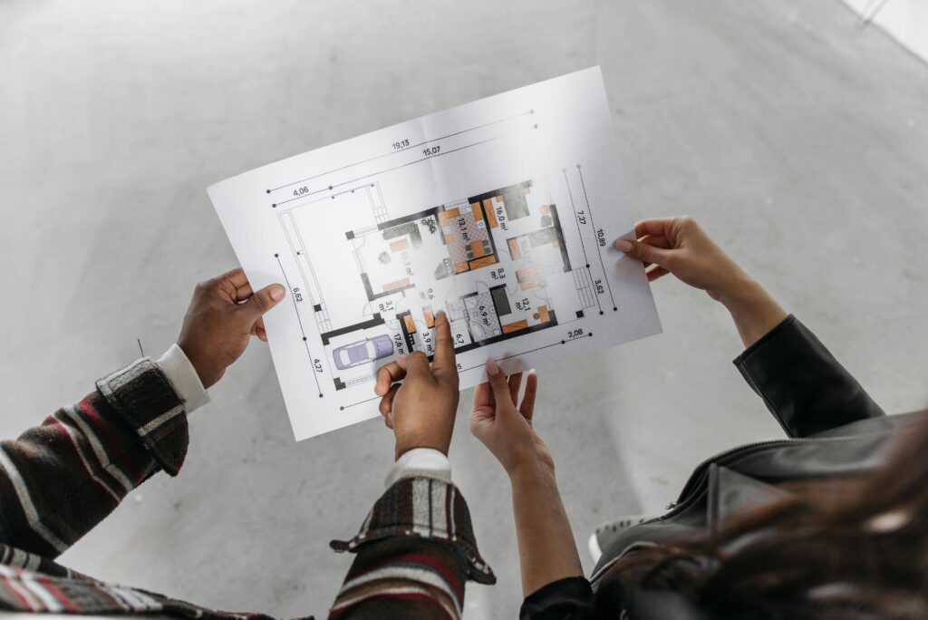 pexels-photo-7937668-7937668 Two people reviewing architectural plans and measuring a new home design.